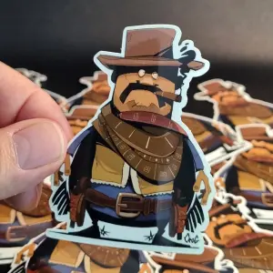 Photo montrant un sticker de cowboy cartoon, création de l'illustrateur CroG. Vente sur la boutique du site.